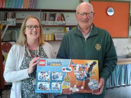 President Scott Elliot hands Lego over to Miss Brady of Wilton School